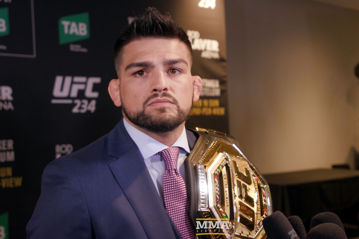 Kelvin Gastelum khoác chiếc đai mới của UFC (có thể mượn từ tay ĐKVĐ Henry Cejudo - khán giả của UFC 234) và tuyên bố mình là nhà vô địch. ufc, ufc 234, robert whittaker, kelvin gastelum, yoel romero, israel andesanya,
