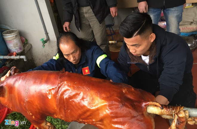 Ông Vũ Văn Hộ (trái) mang lợn nhờ hàng xóm quay, sau đó hướng dẫn Văn Thanh mổ lợn chia lên các mâm cỗ mời họ hàng, láng giềng chiều 27 Tết. van thanh, u23 viet nam, vu van thanh, gia dinh an tet