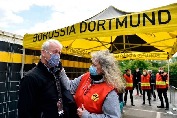 Một nhân viên của Dortmund đo thân nhiệt cho 1 thành viên của BTC - Ảnh: Getty Images Bundesliga, vòng 26 Bundesliga, kết quả Dortmund vs Schalke, kết quả Union Berlin vs Bayern Munich, Haaland